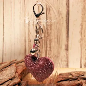 Detailaufnahme der Glitzerseite des Herz-Taschenanhängers mit Metallperle und Schlüsselring.