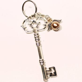 Detailaufnahme Schlüsselanhänger goldener Vintage-Schlüssel mit abnehmbarem Engel-Charm und Strass auf Holzgrund – Handgefertigt von chic-peppig-bunt Deutschland.