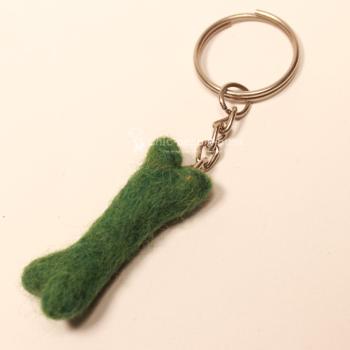 Handgefertigter Mini Knochen aus grünem Filz als witziger Schlüsselanhänger und weicher Taschenbaumler, Gesamtansicht.