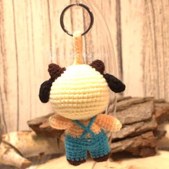 Nahaufnahme des gehäkelten Kuh-Taschenbaumlers aus Wolle. Gesamthöhe 16 cm, World Fair Trade, Hellblau.