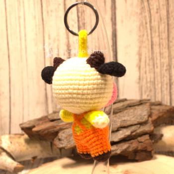 Nahaufnahme des gehäkelten Kuh-Taschenbaumlers aus Wolle. Gesamthöhe 16 cm, World Fair Trade, Orange.