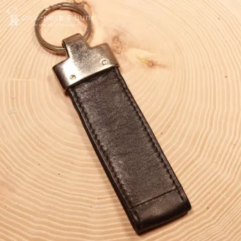 Leder Taschenbaumler destino befestigt an einer Reisetasche zur Größenveranschaulichung.
