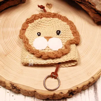 Handmade Löwen Schlüsselanhänger Rückseite mit hellrosa Perle auf einer Holzscheibe dekoriert