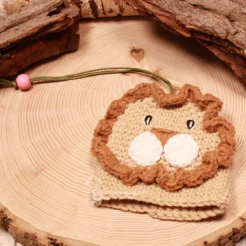 Handmade Löwe Taschenbaumler flach liegend mit langgezogener grüner Stoffschnur und rosa Perlen-Stopper.