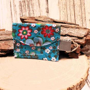 Handgenähtes farbenfrohes Schlüsselmäppchen von chic-peppig-bunt mit Kunststoff-Druckknopf und silbernem Schlüsselring auf hellem Hintergrund.