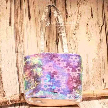 Kleine lila-blau schimmernde Kindertasche mit Sternen-Pailletten, grauen Kunstleder-Griffen und Reißverschluss auf hellem Untergrund.