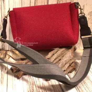 Rote Filz Handtasche quer getragen, zeigt die Maße und das kompakte Design.