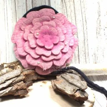 Runde rosa Umhängetasche aus Filz in Blumenform mit glitzernden Perlen und sicherem Reißverschluss.