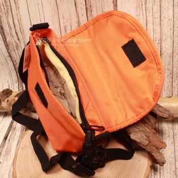 Rückseite der orangefarbenen Radltasche aus Nylon-Stoff mit Fokus auf das verstellbare Schulterband.