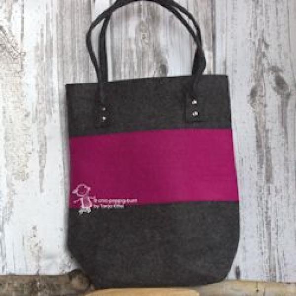 Große pinke Shoppertasche aus Filz mit stabilen Metallnieten an den Henkeln, handgefertigt, vor weißem Hintergrund.