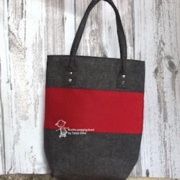 Große rote Shoppertasche aus Filz mit stabilen Metallnieten an den Henkeln, handgefertigt, vor weißem Hintergrund.