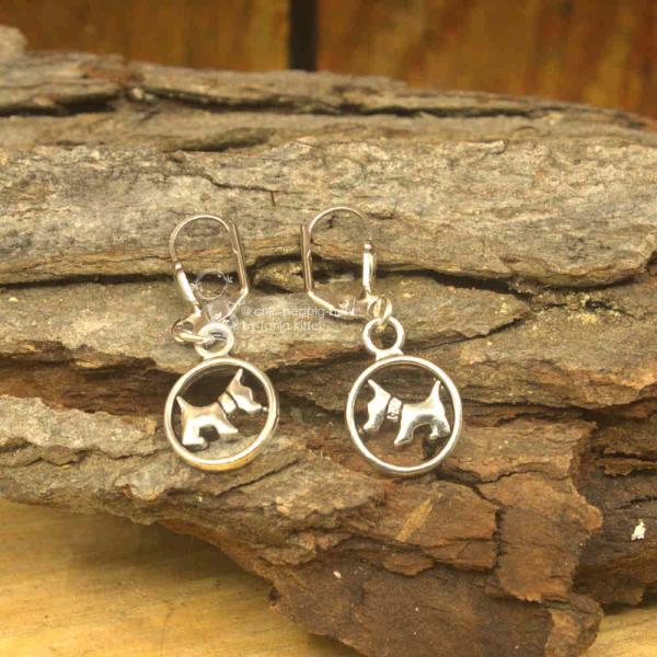 Die versilberten Ohrringe als Hänger mit kleiner Hund
