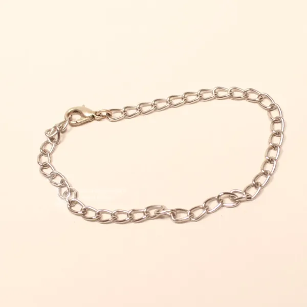 Ausgebreitetes silbriges Bettelarmband aus leichtem Aluminium mit großen Gliedern und Karabiner-Verschluss..