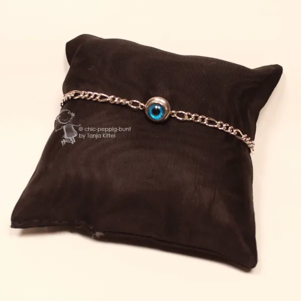 Filigranes, versilbertes Metall-Armband mit mittig platziertem Evil Eye (blaues Nazar-Auge) vor hellem Hintergrund.