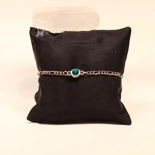 Frontalansicht des versilberten Metall-Armbands auf dunklem Schmuckkissen mit Fokus auf den gefassten Stein.