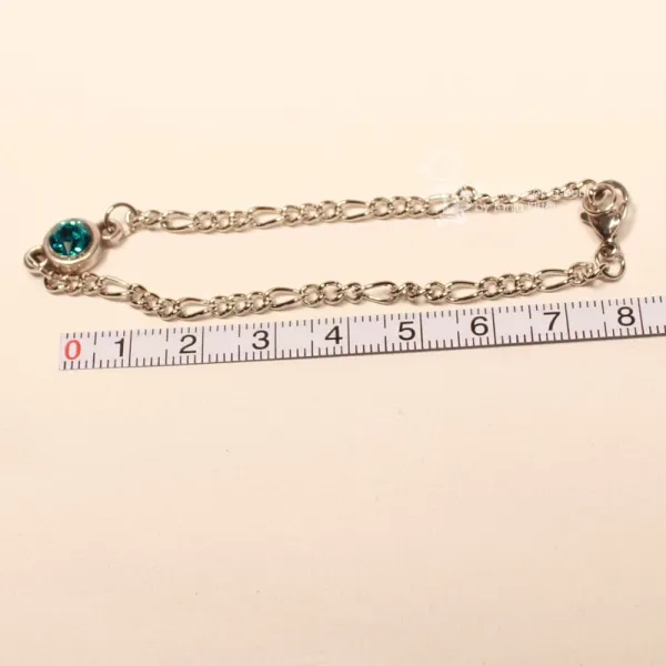 Versilbertes Bettelarmband an einem Maßband zur Veranschaulichung der Gesamtlänge von 19 cm.