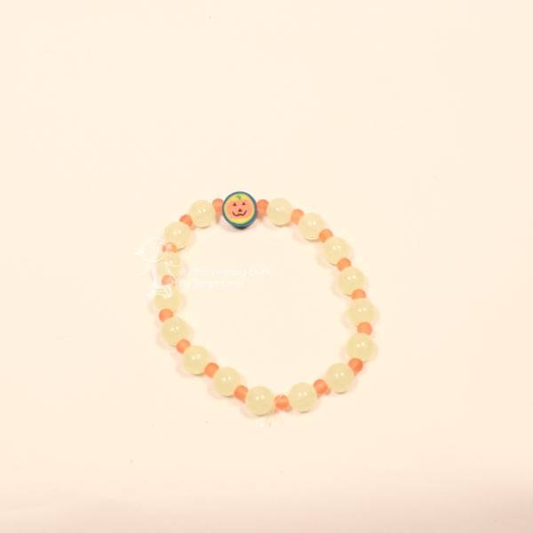 Elastisches Perlenarmband für Halloween und Fasching mit leuchtenden fluoreszierenden Perlen und orangefarbenen Mini-Perlen.