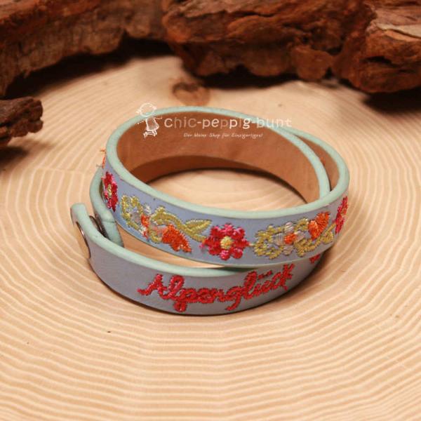 Nahaufnahme der Blumen-Stickerei auf dem hellblauen Trachten-Wickelarmband.