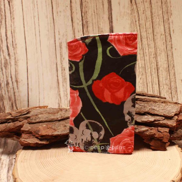 Handgenähtes Brillenetui von chic-peppig-bunt mit schwarzem Blumenmuster und rot-weiß kariertem Innenstoff auf hellem Hintergrund.