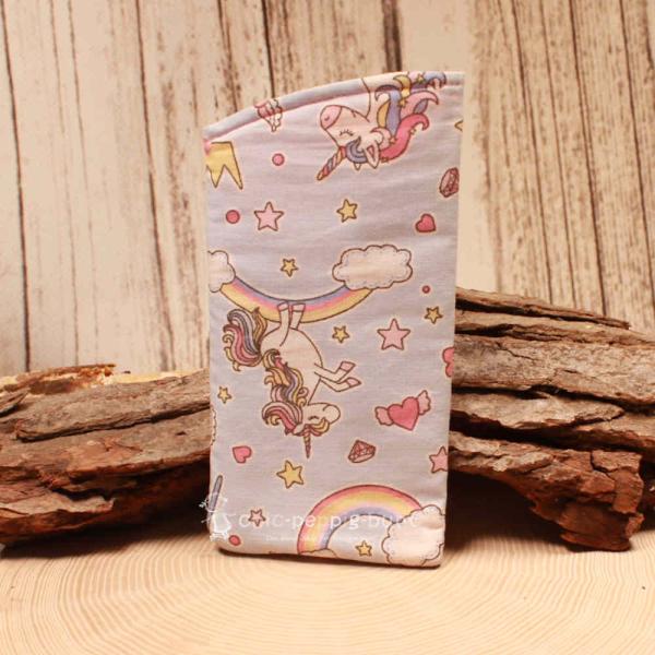 Handgenähtes hellblaues Brillenetui von chic-peppig-bunt mit Einhorn-Regenbogen-Motiv und rosa-pink gepunktetem Innenfutter auf hellem Hintergrund.