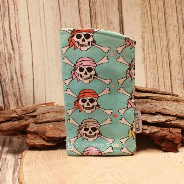 Handgenähtes Brillenetui von chic-peppig-bunt in Türkisblau mit Totenkopf-Muster und rosa-pink punktiertem Innenstoff auf hellem Grund.