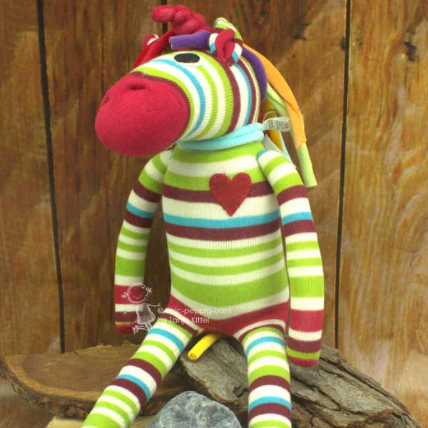Kuscheltier als Einhorn mit bunten Streifen Kuscheltier als Einhorn mit bunten Streifen