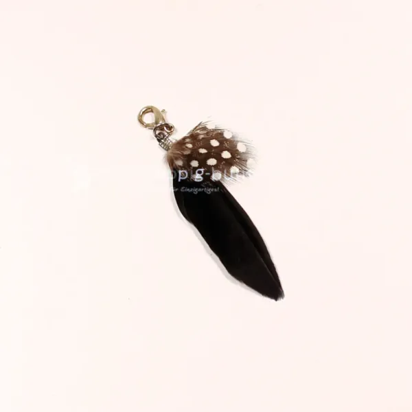 Schwarzer Charmsanhänger Feder mit weißen Polka Dots und Metall-Karabiner.
