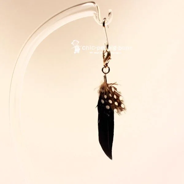 Schwarzer Taschenbaumler Feder mit Punkten (5x2 cm) für Schlüssel und Taschen.