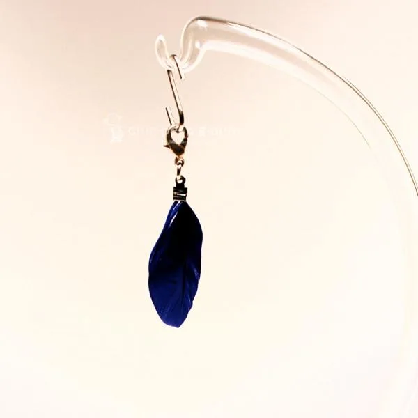 Detailansicht der blauen Feder (6x2 cm) als Kettenanhänger an einem eleganten Bettelarmband.