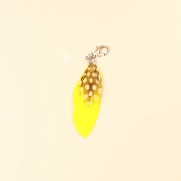 Gelber Charmsanhänger Feder mit weißen Polka Dots und silbernem Karabiner.