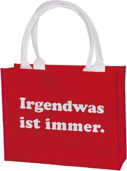Rote Shoppertasche aus Polyester mit weißem Aufdruck „Irgendwas ist immer“ und stabilen Griffen.
