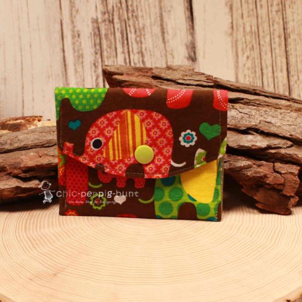 Kleiner handgenähter Geldbeutel von chic-peppig-bunt aus braunem Stoff mit Elefanten-Motiv und grün gepunktetem Innenfutter auf hellem Hintergrund.