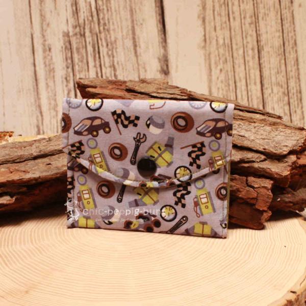 Kleiner handgenähter Geldbeutel von chic-peppig-bunt aus grauem Stoff mit Auto-Motiv und grün gepunktetem Innenfutter auf hellem Hintergrund.