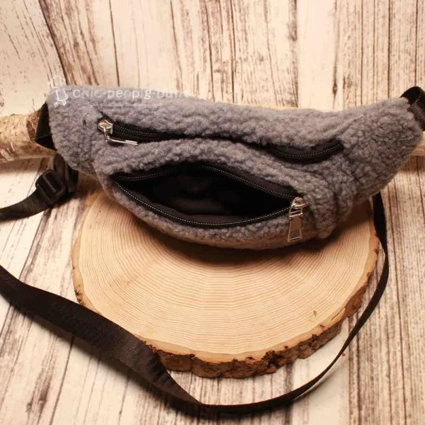 Detailaufnahme des geöffneten Hauptfachs der grauen Hüfttasche mit viel Stauraum.