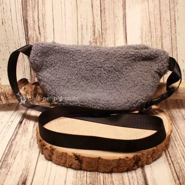 Rückseite der plüschigen Bauchtasche zur Ansicht des verstellbaren Gurtes und Klickverschlusses.