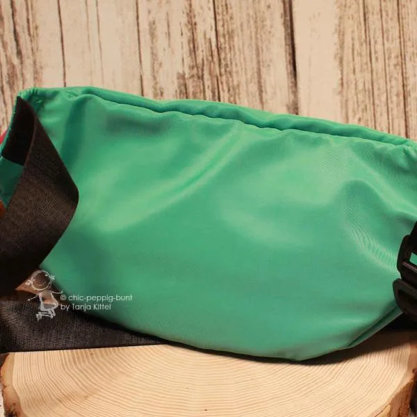 Schräge Detailaufnahme der Bauchtasche zur Veranschaulichung der beiden vorderen Reißverschlussfächer.