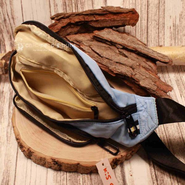 Trageweise der blauen Hip Bag aus Nylon-Stoff als praktische Schultertasche mit den Maßen 30x14 cm.