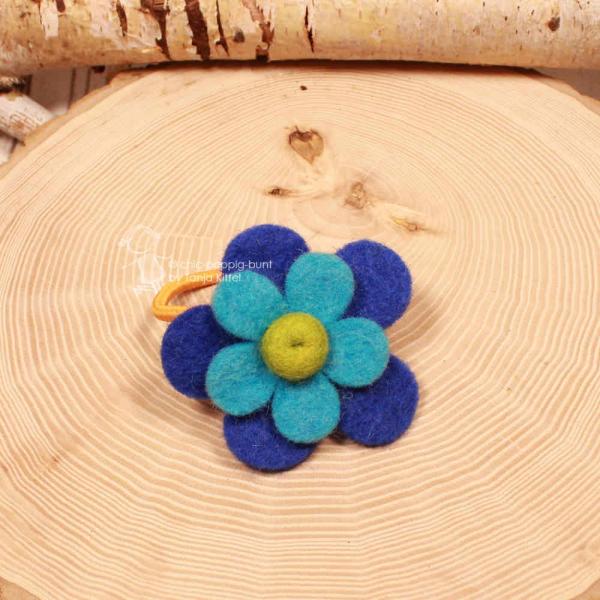 Handgefertigtes blaues Filz-Haargummi für Kinder mit großer Blume und leuchtend orangefarbenem Gummiband.