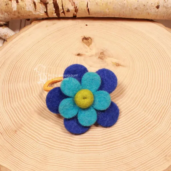 Handgefertigtes blaues Filz-Haargummi für Kinder mit großer Blume und leuchtend orangefarbenem Gummiband.