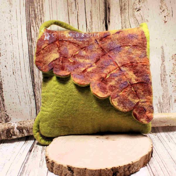 Handgefertigte graue Umhängetasche aus Filz mit einem Überschlag in Blattform und langem runden Trageband vor neutralem Hintergrund.