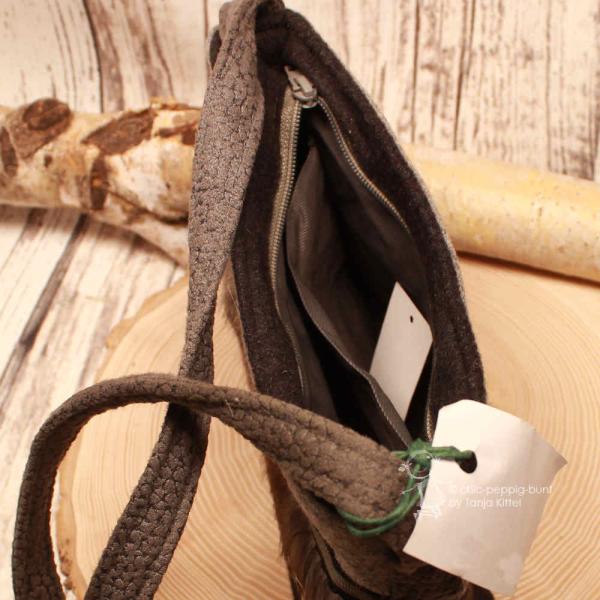 Detailansicht der geöffneten Filztasche mit Reißverschluss, großem Innenfach und kleinem Zusatzfach.