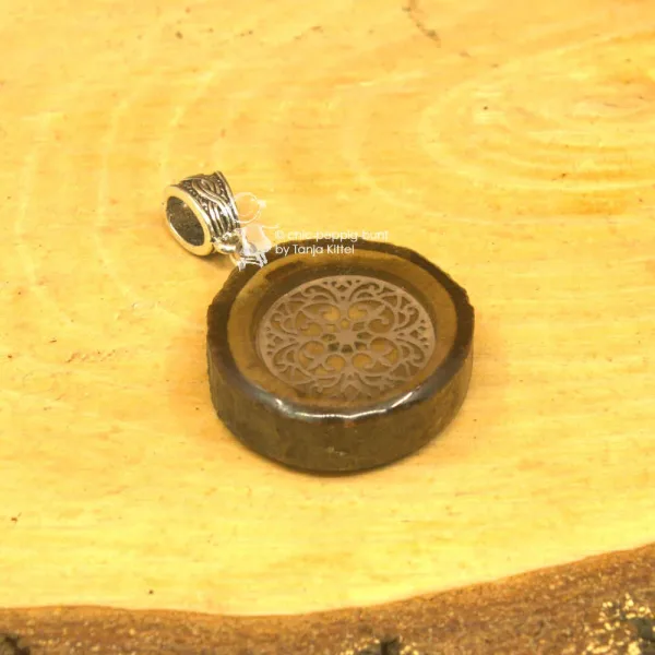 Ornament in Baumscheibe als Kettenanhänger