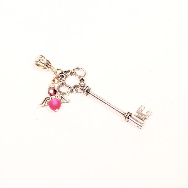 Handgefertigter Kettenanhänger in Schlüsselform mit einem Schutzengel aus einer pinken Polarisperle, hochwertig versilbert.