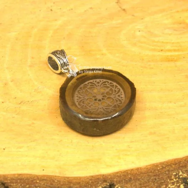 Ornament in Baumscheibe als Kettenanhänger