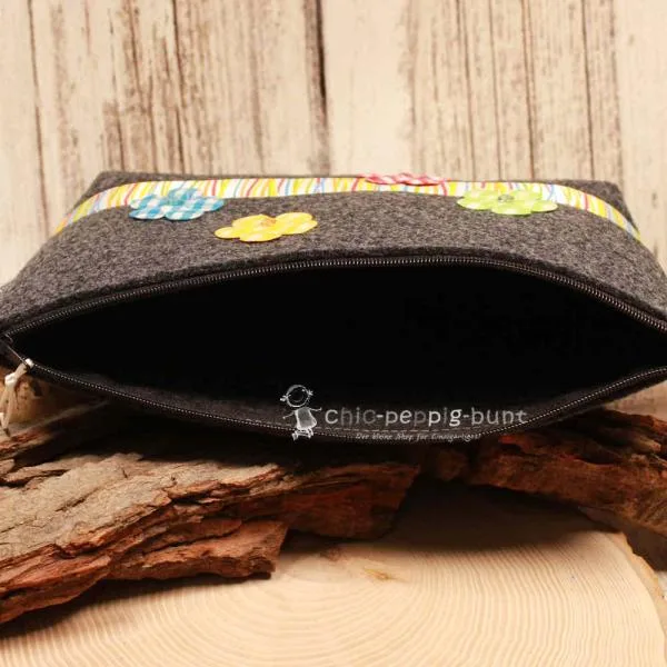 Nahaufnahme der Blumen-Stickerei und der bunt gestreiften Bordüre auf der Handmade Kulturtasche.