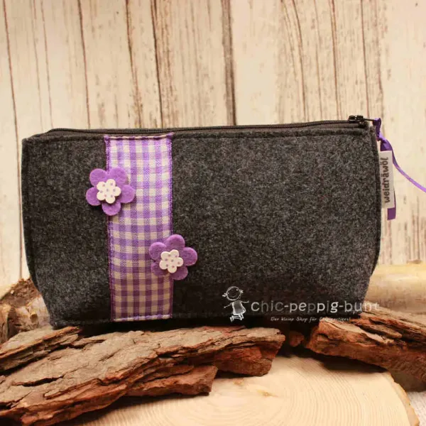 Handgenähte dunkelgraue Filz Kosmetiktasche mit lila Karoband und Blumen-Applikationen.