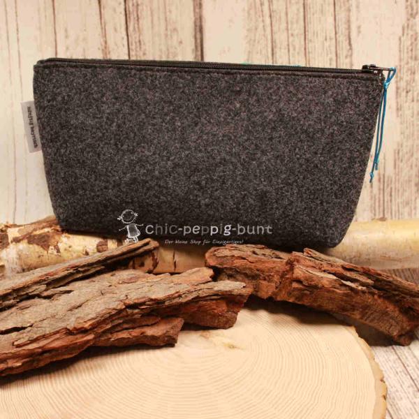 Filz-Kosmetiktasche 24x12 cm von weidräwöl auf einem Holztisch.