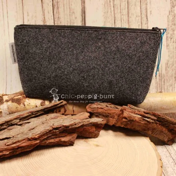 Filz-Kosmetiktasche 24x12 cm von weidräwöl auf einem Holztisch.