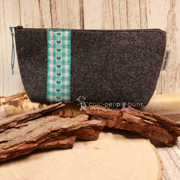 Handgenähte weidräwöl Kosmetiktasche aus dunkelgrauem Filz mit Herz-Motiv und türkis-grüner Karo-Bordüre.