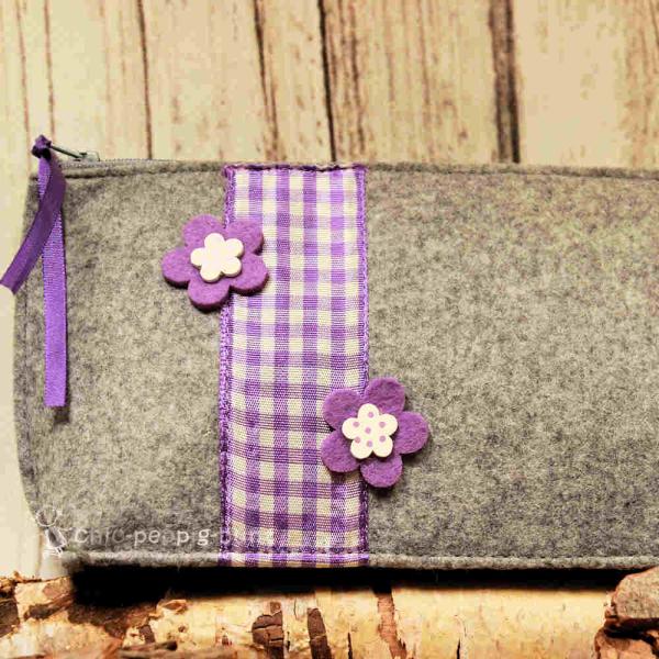 Stabiler Reißverschluss der handgenähten hellgrauen Utensilientasche aus Filz.